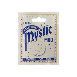 Mystic Mud. A white, sealed, sachet product. The packaging is white with a moon and star border and a crescent moon illustration in the centre. The blue text reads "LUSH Mesmerising Mystic Mud Powdered Face Mask.