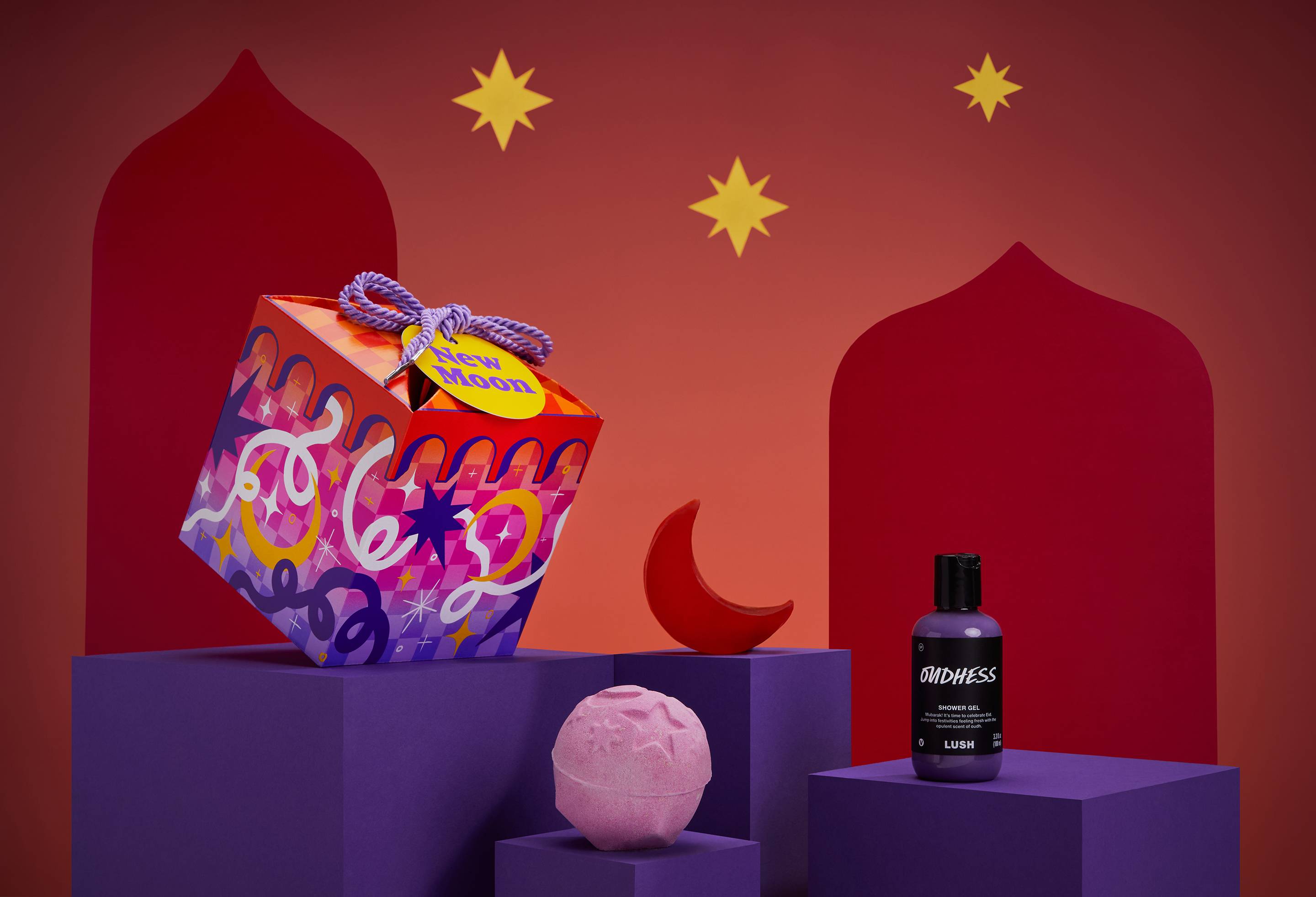 The image shows the New Moon gift box on a purple platform with three Eid-themed products on a red starry background.