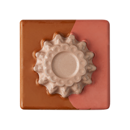 A square, two-toned block of Glam Nudes ~ Lip square with glossy terracotta brown and matte peachy nude sections. The center features a raised, textured, circular design in pearlescent champagne nude.