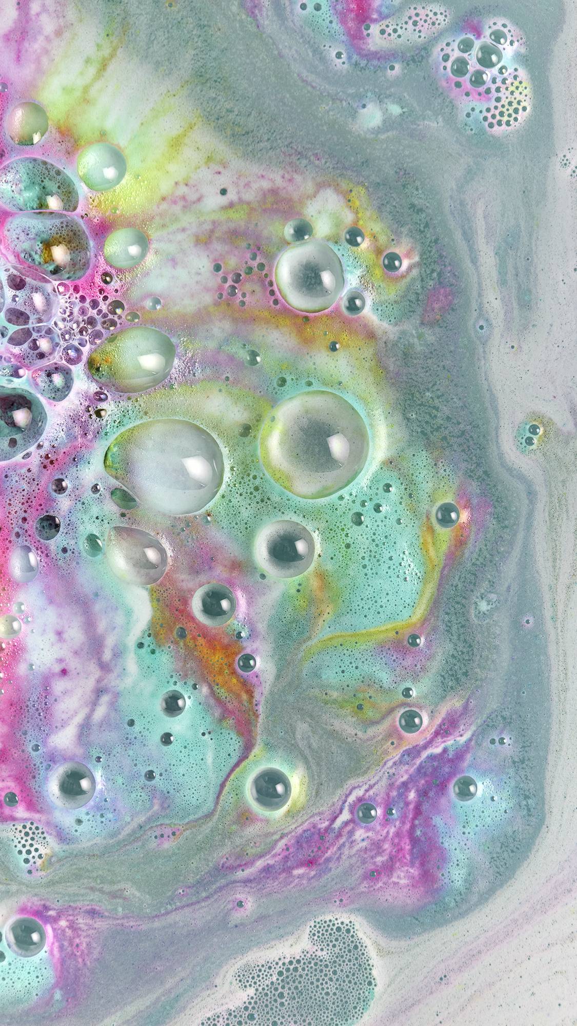 The bath bomb has fully dissolved leaving a swirling galaxy of blue, pink, yellow, green, purple and red.