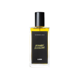 A glass perfume bottle filled with light amber liquid. A black label reads 'The Perfume Library' and 'Orange Blossom'.