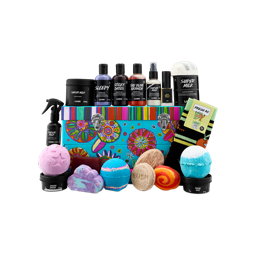 Full contents of the Peace and Love gift set on a black background. A blue floral trunk is surrounded by Lush products including shower gels, bath bombs, a Super Milk candle, perfume, and 'Fresh As' socks.