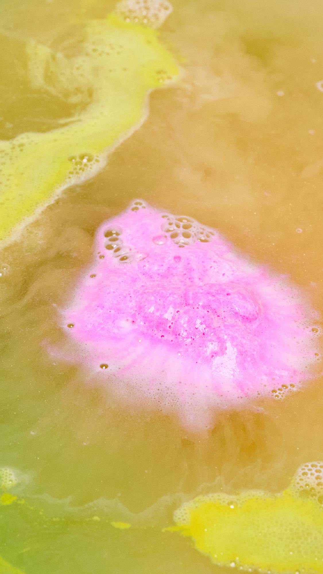 The Pig In A Poke bath bomb has dissolved leaving behind fresh, golden bath water laced with thin, velvety foam and a flash of pink in the centre. 