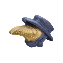 Plague Doctor. A bath bomb shaped like a plague doctor's head. The figure wears a dark purple brimmed hat and cowl, while the iconic long, beaked mask is covered in a glittering metallic gold finish.