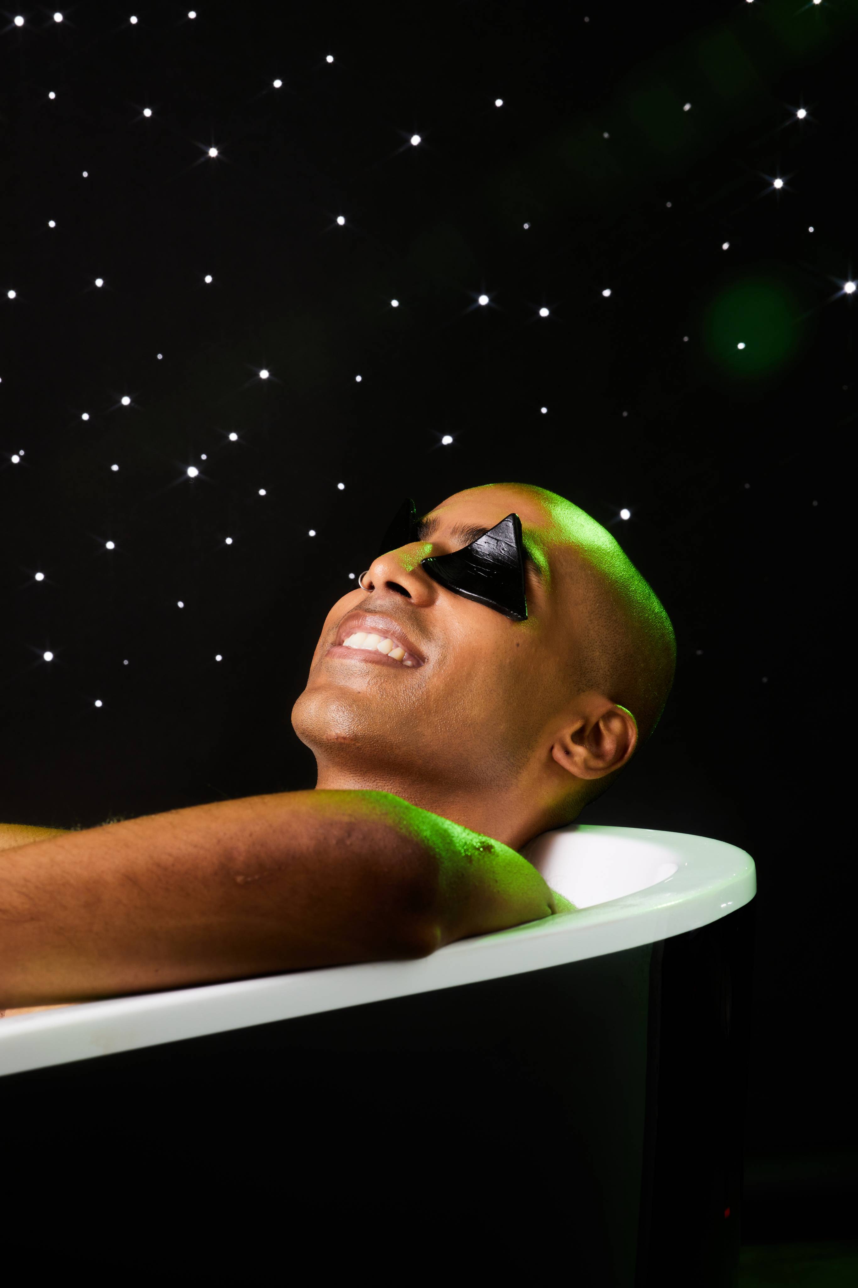 Image shows the model laid back in the bath, relaxing, with the Pumpkin Eye Pads in place on a black, twinkling background.
