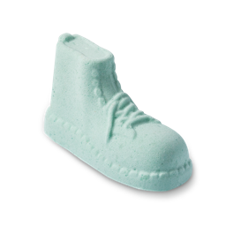 Put The Boot In. A pale mint-green, foot soak product shaped like a high-top boot. It features embossed details of laces, eyelets, and a textured sole, appearing solid and porous, similar to a bath bomb.