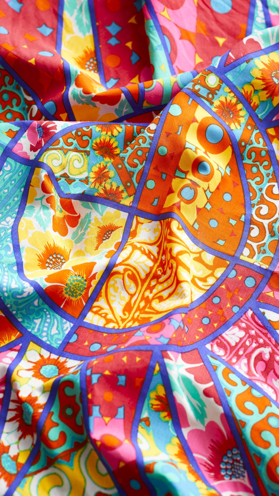 The image shows a close-up of the Quilted Sun knot wrap focusing on the sheen of the fabric. 