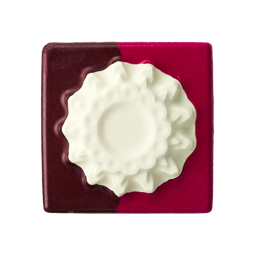 A square, two-toned block of Rocket Pocket Pink ~ Lip square with glossy deep burgundy and vibrant hot pink sections. The center features a raised, textured, circular design in creamy off-white.