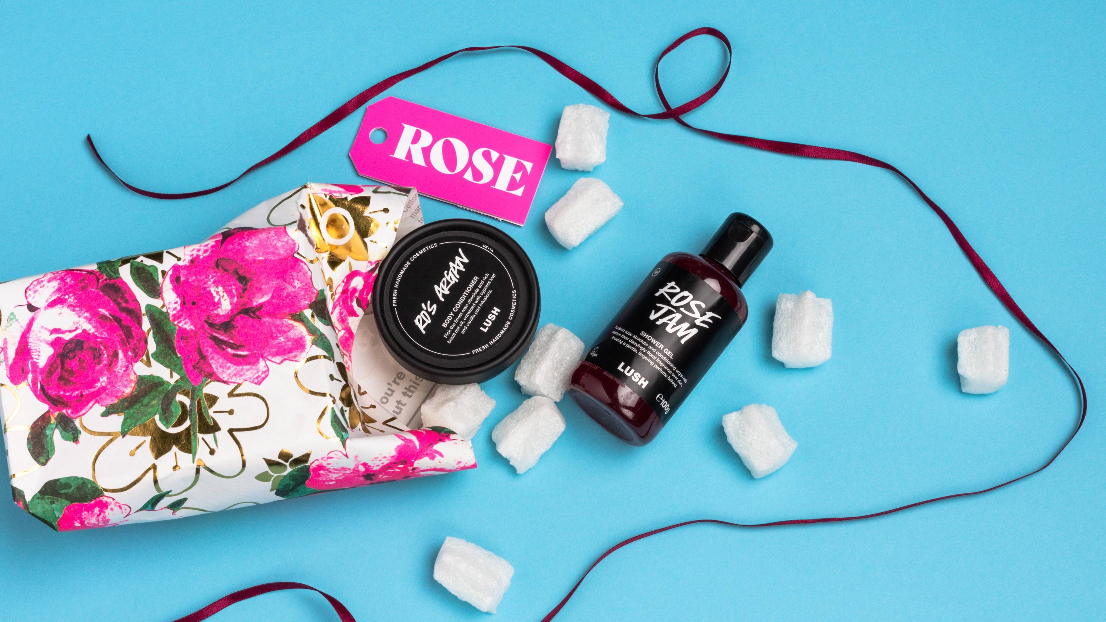 Rose, opened onto a light blue background, with its included products and eco packaging pops arranged randomly.