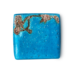 Rub Rub Rub. A cube-shaped, vibrant turquoise product. One corner features a rough brown patch with salt crystals. The blue surface is smooth with tiny flecks.
