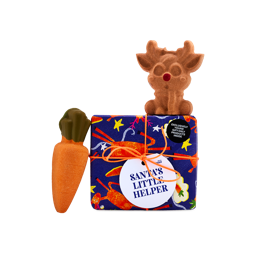 A Lush Santa's Little Helper gift box wrapped in dark blue pattern with an orange string, next to an orange carrot bath bomb and topped with a brown reindeer bath bomb