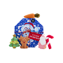 A Lush Santa's On His Way gift set in a blue, octagonal box, surrounded by five festive bath products including a Christmas tree, reindeer, Father Christmas, candy cane, and carrot-shaped bath products.