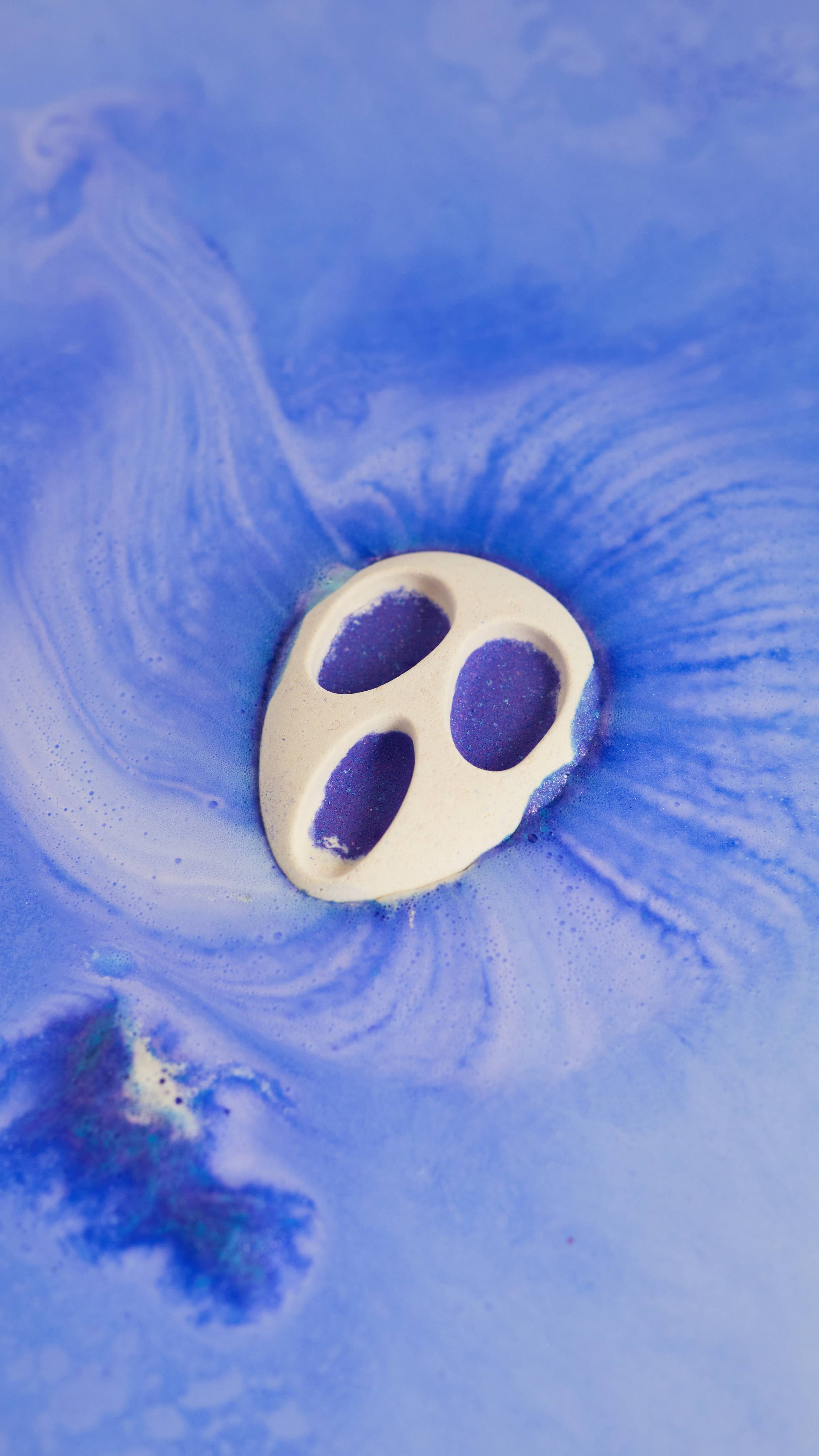 Screamo bath bomb slowly dissolves in the bath water revealing endless velvety swirls of deep indigo and blue foam.