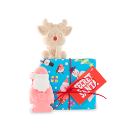 Secret Santa. A square gift box wrapped in blue paper with illustrations of presents, Christmas trees, Santa, Robins and snowmen, tied with a red ribbon and gift tag. Two Christmas-themed products sit around the box.