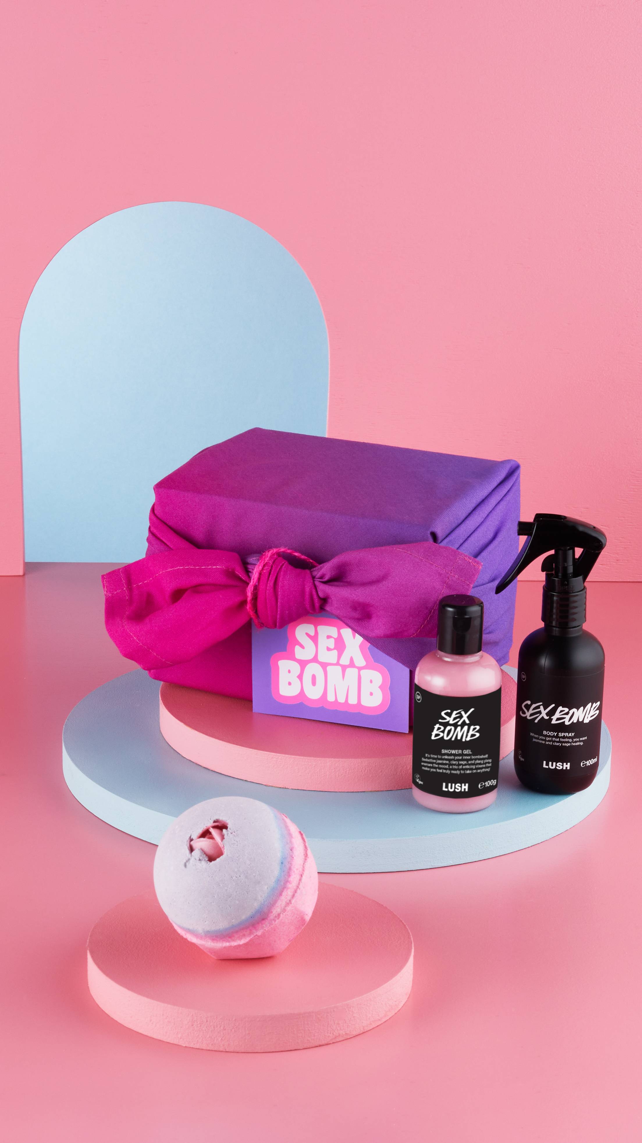 The Sex Bomb wrapped gift box sits surrounded by the included shower gel, bath bomb and body spray.