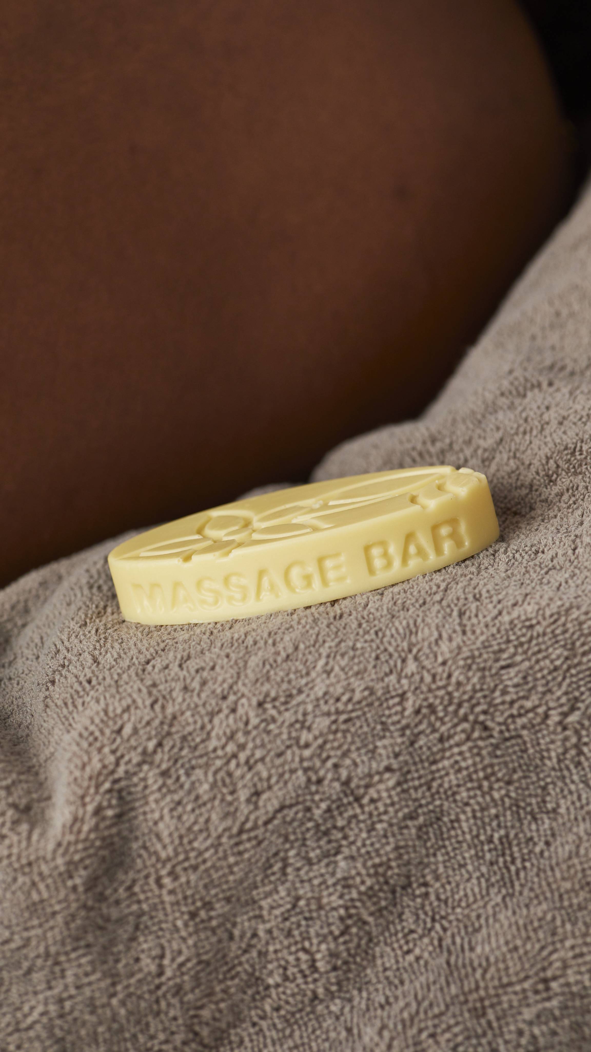 The image shows a super close-up of the Sex Bomb massage bar as it sits on a light brown towel. 