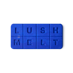 A solid, bright blue bath melt with "LUSH" embossed on the top four squares and "MELT" on the bottom four, creating a tactile, alphabet-block-like appearance.