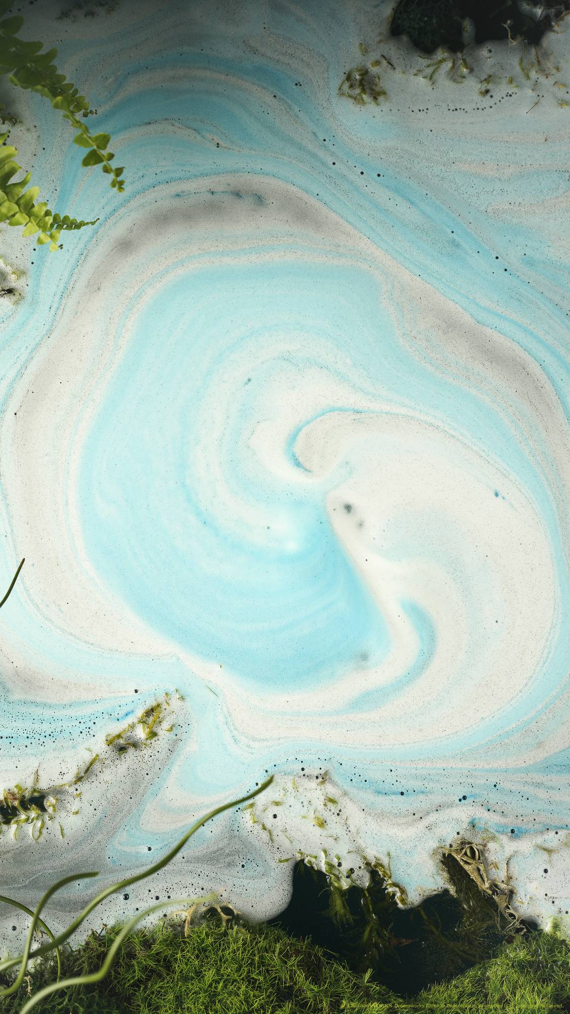The Donkey bath bomb has fully dissolved leaving behind a thick, velvety blanket of electric blue and crisp white foamy waves. Moss and foliage line the borders. 