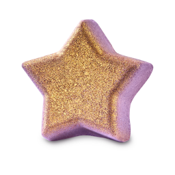 A five-pointed star-shaped Siraj bath bomb. The base is a soft lilac-purple, and its front face is heavily coated in shimmering gold glitter.