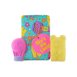 Sky's The Limit. A rectangular gift box wrapped in colourful paper designed with bears, hot air balloons, flowers and stars, tied with an orange string and pink tag. Two themed bath bombs sit in front of the box.