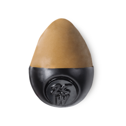Slap Stick 25W. A medium dark-warm, caramel brown, egg-shaped solid foundation, with a black wax base.