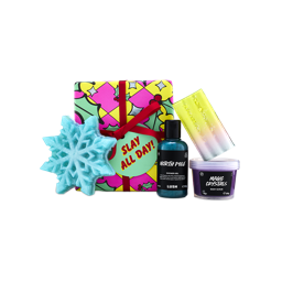 A Lush "Slay All Day!" gift box tied with red ribbon, surrounded by North Pole shower gel, Magic Crystals body scrub, soap slice, and a blue snowflake shower gummy.