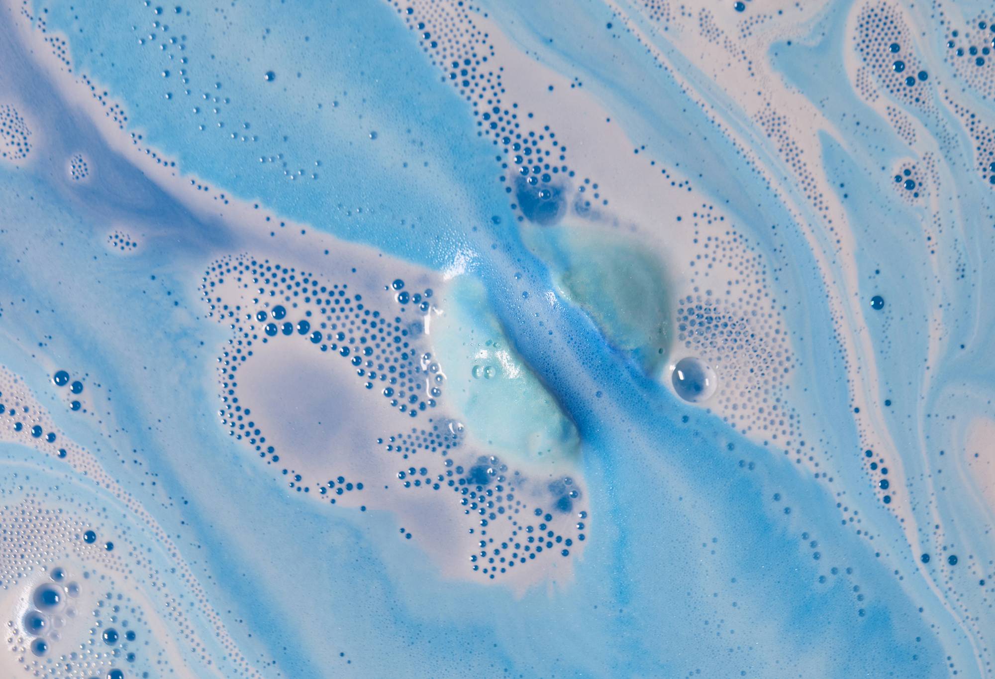 Snowdrift bath bomb fizzes away leaving magical, icy swirls of blue and white foam.