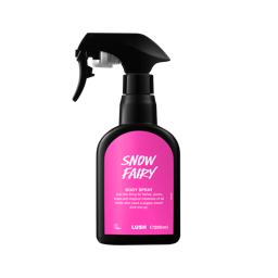 A recycled black plastic LUSH body spray bottle with a trigger nozzle stands upright with a vibrant pink label that reads "Snow Fairy Body Spray" and includes the product's whimsical description.