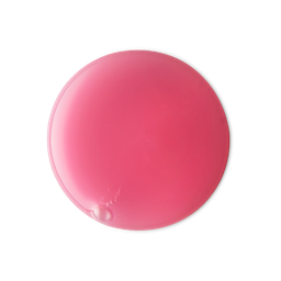 A smooth, glossy, circular puddle of LUSH Snow Fairy shower gel is shown against a light grey background. The vibrant pink product has a few small air bubbles in it.