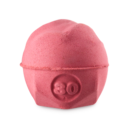 Sticky dates. A wavy, spherical bath bomb with a flat, geometric base. The product is a warm, caramel/rust colour and has the number "30" embossed on the side. 