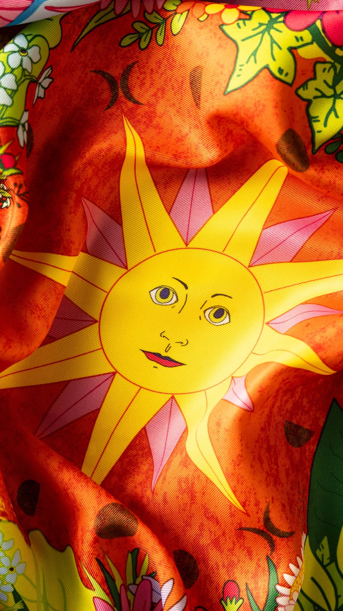 Image shows a super close-up of the centre of the knot wrap focusing on the vibrant yellow and orange sun. 