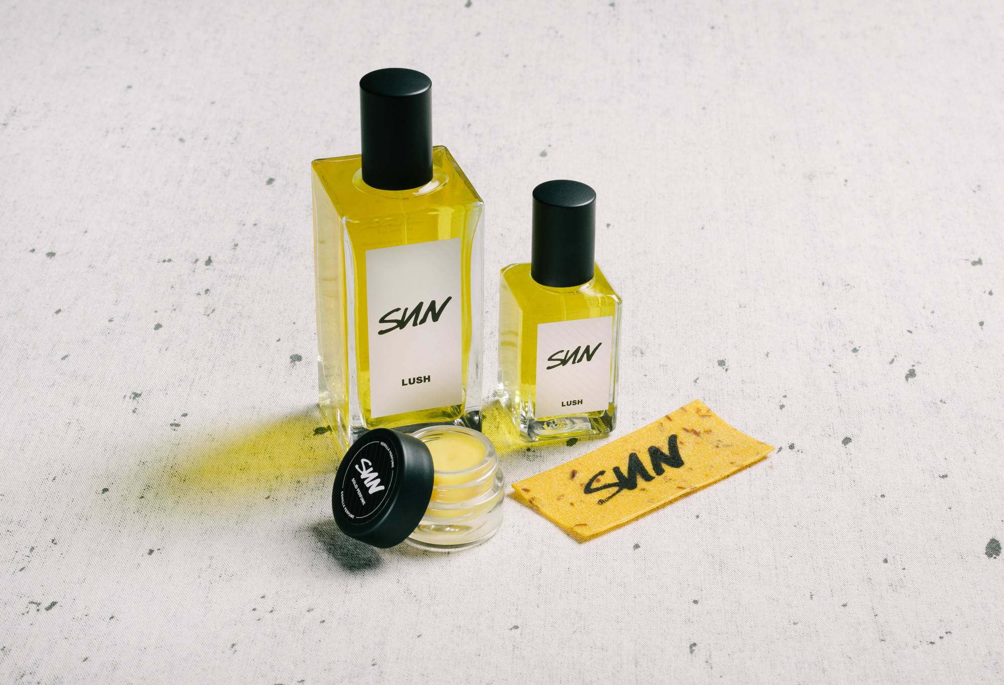 The whole Sun fragrance collection is displayed on a white surface, flecked with grey.