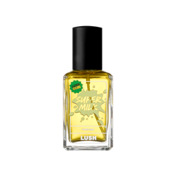 A clear glass bottle of Lush "Super Milk" perfume containing golden-yellow liquid fragrance, with a black spray cap and a light green splash-graphic label featuring a green "Lush Club" sticker