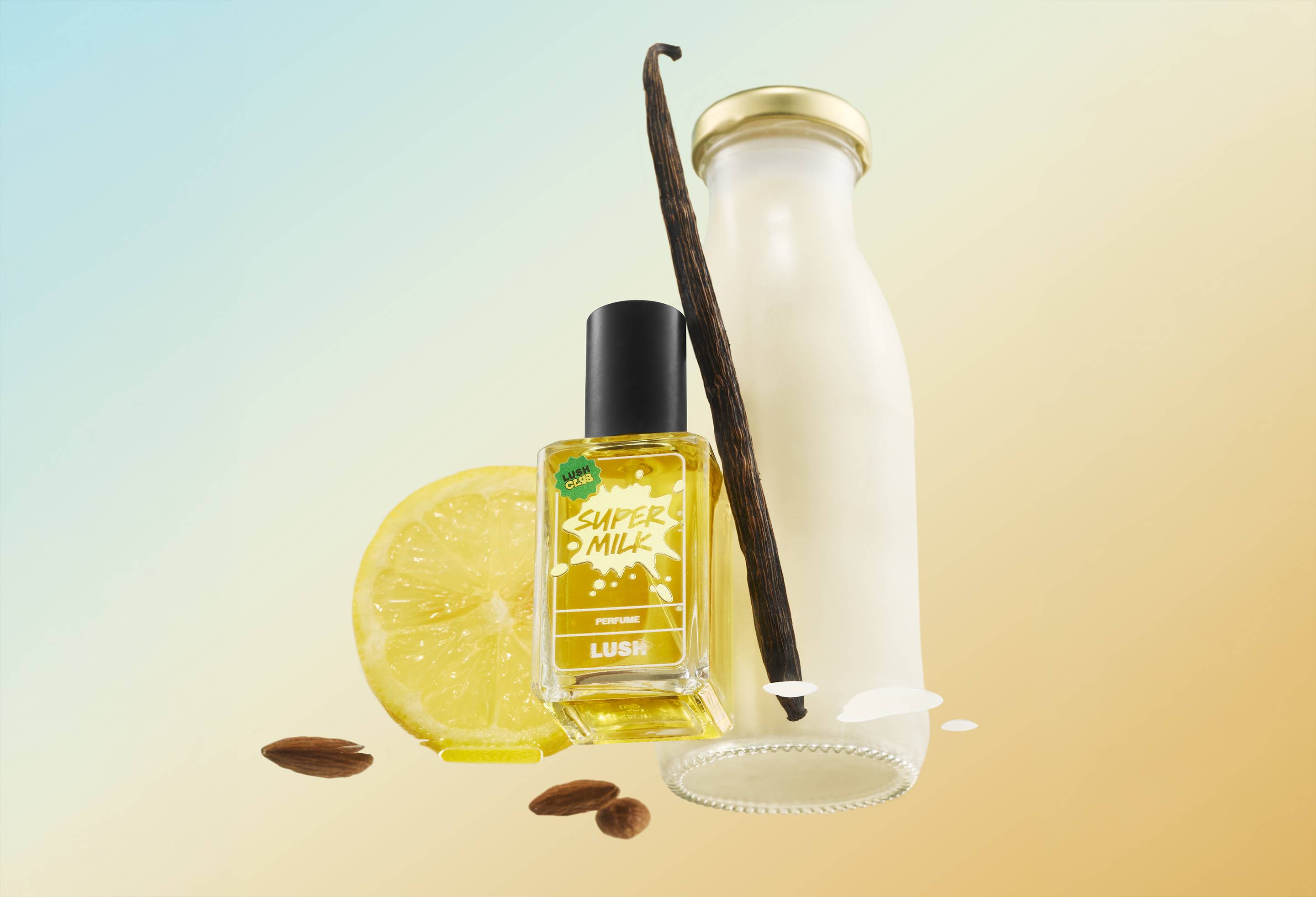 A bottle of Lush Super Milk perfume floating alongside a glass milk bottle, a vanilla pod, a lemon slice, and almond nuts against a pastel blue-to-yellow gradient background.   