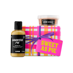 Sweet As Pie. A Lush gift set featuring a box wrapped in pink, orange, and white checked paper with a purple ribbon. It is presented with a bottle of Banoffee Pie shower gel and a pot of Crème Brûlée body scrub.