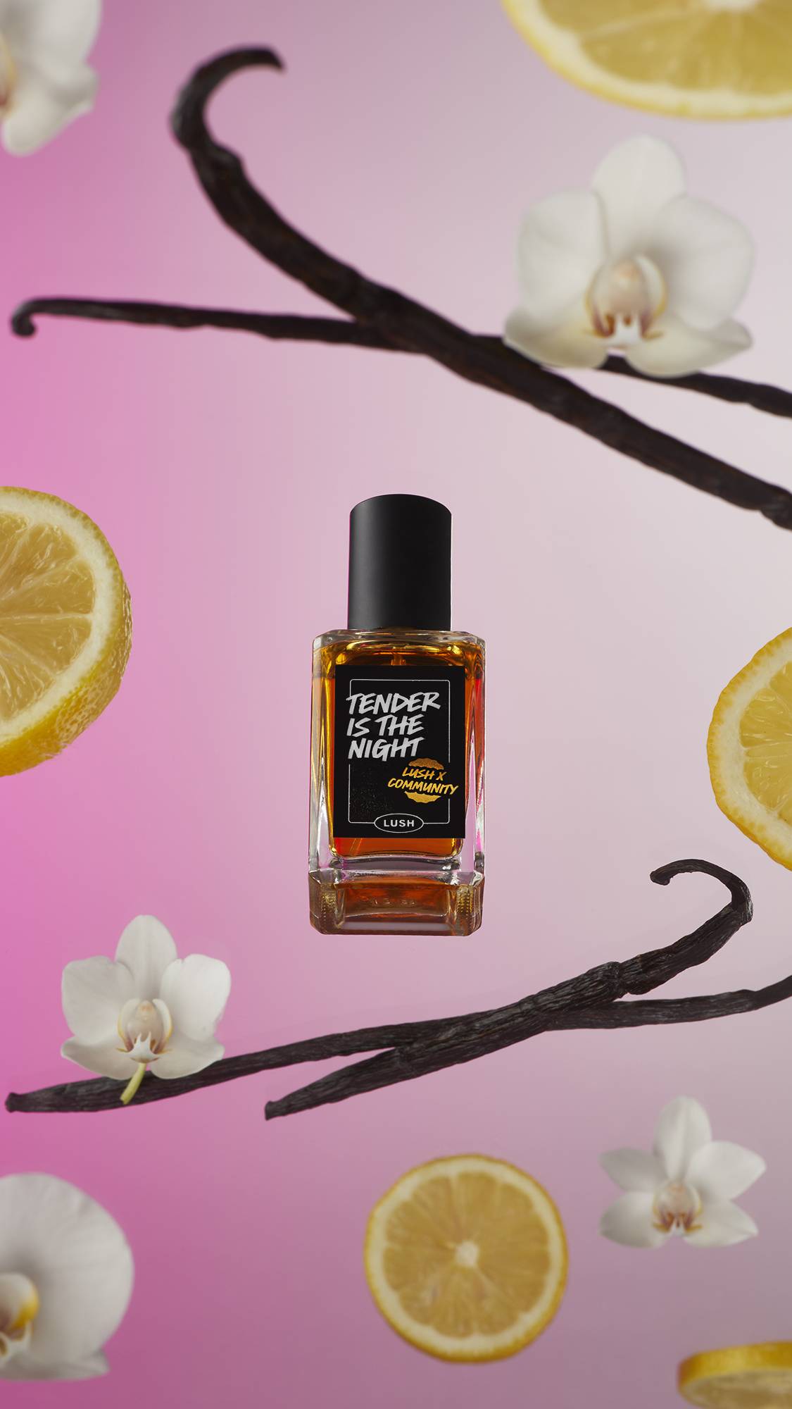 The Tender Is The Night perfume bottle is on a pink and white background surrounded by vanilla pods, flowers and lemon slices.