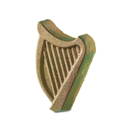 The Craic. An Irish, St. Patrick's Day-themed bath bomb shaped like an elegant harp. The edges show hints of bright yellow and green colouring while the front is covered in a glittering, golden lustre. 