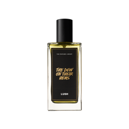 A Dew On Their Hems. A rectangular, glass perfume bottle with a black cap is filled with translucent, amber liquid. A black label reads 'The Dew On Their Hems'.