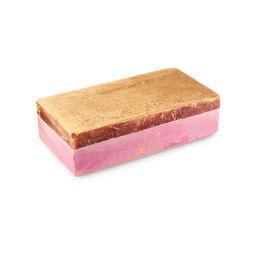 A rectangular soap bar with two distinct layers. The top layer is a shimmering metallic gold with a rustic texture, while the bottom layer is a smooth, vibrant pink. The bar is shown against a plain grey background.