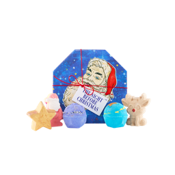 The Night Before Christmas. An octagonal-shaped gift box with a blue, starry design and a large illustration of a Santa face, tied with red string and a white gift tag. Five Christmas-themed bath bombs sit in front of the box.