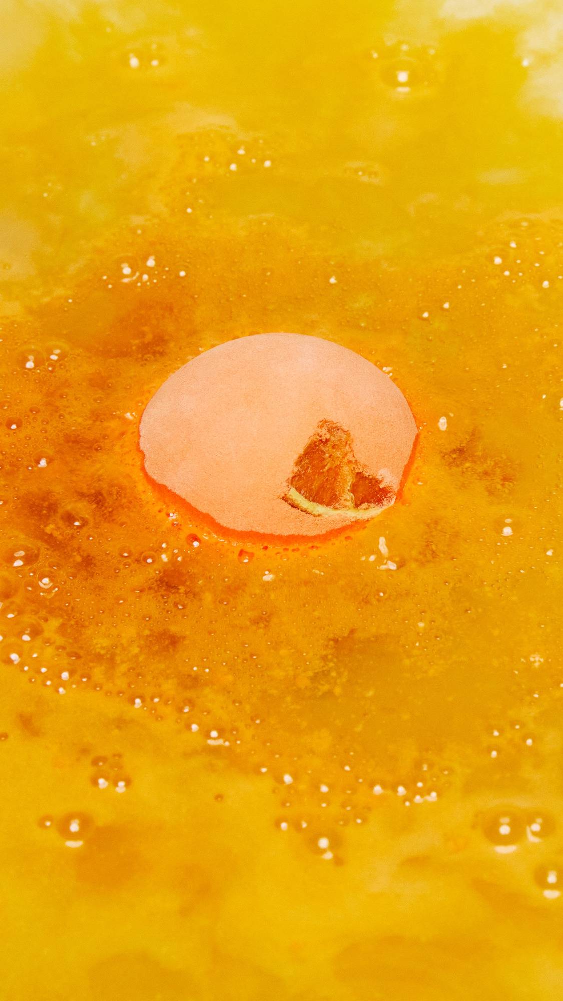 The One With The Orange Slices is sitting gently in the bath as it begins to give off vivid orange foamy bubbles. 