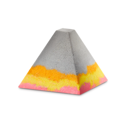 Volcano. A grey, pyramid-shaped bath bomb-style foot soak. The base features layered, wavy bands of vibrant orange, yellow, and bright pink, creating a colourful contrast against the neutral grey upper half. 