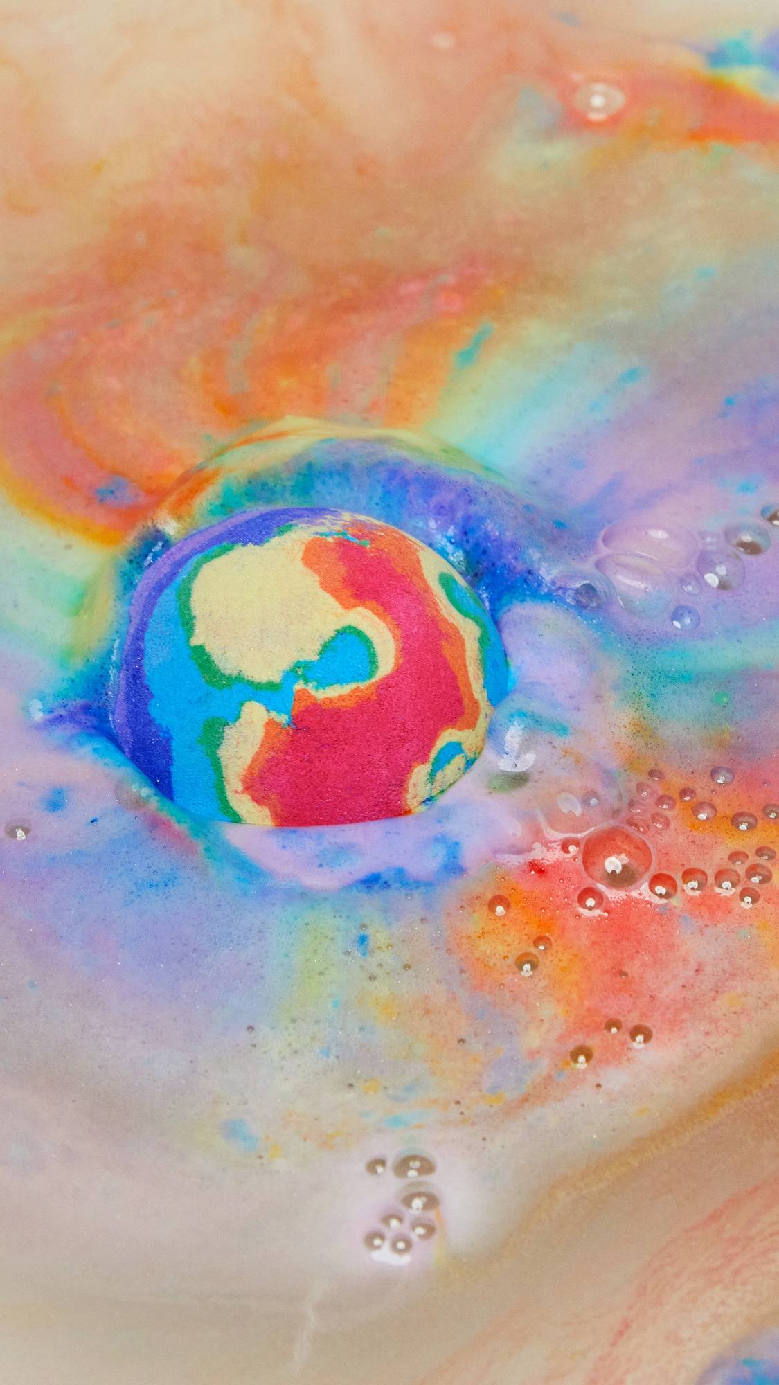 The Thermal Waves bath bomb has been placed into the bath water where it creates a thick foam across the top of the water with vibrant swirls of every single colour. 