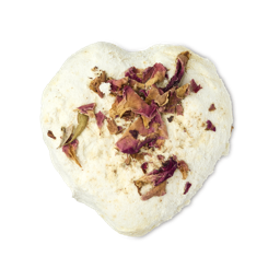 Tisty Tosty. A cream-coloured heart-shaped bath melt. The top of the melt is decorated with scattered dried rose petals sprinkled on the surface. 