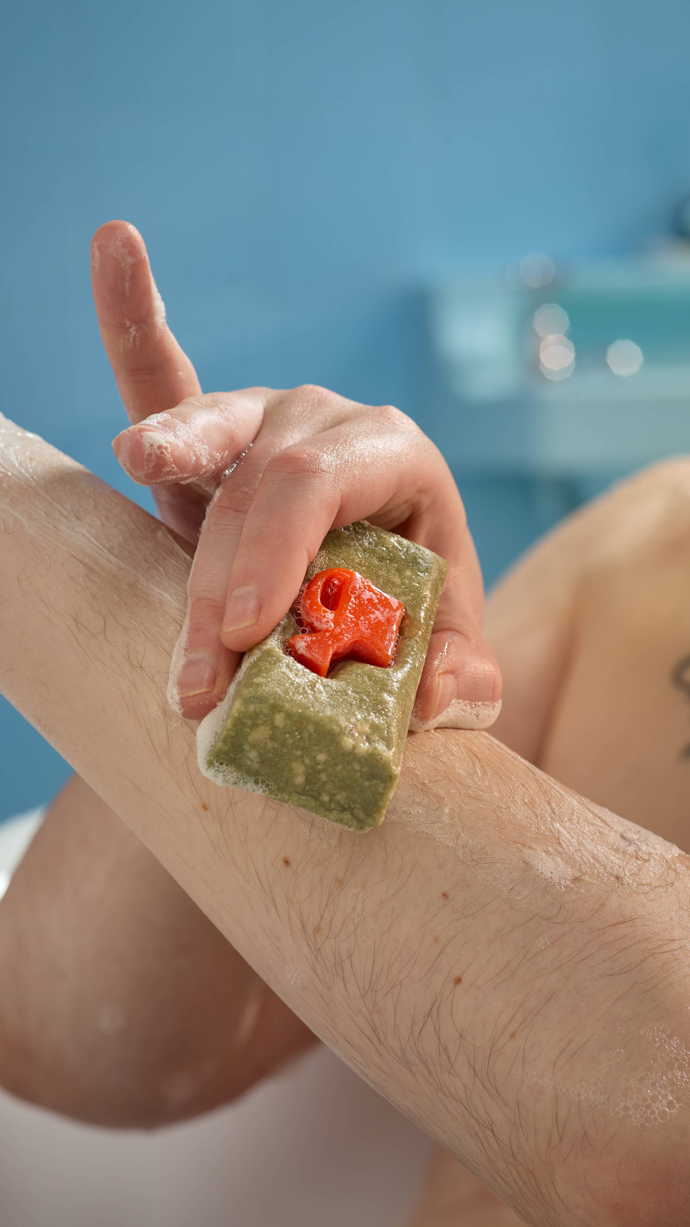 A close-up image of the model using the True Grit soap on their forearm in a bac-and-forth, exfoliating motion.
