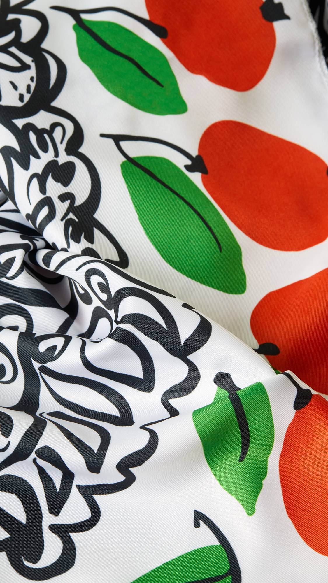 A super close-up image of the Under The Orange Tree knot wrap with the lighting focusing on the texture of the material and the vibrant, contrasting colours. 