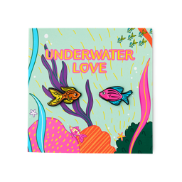 The Underwater Love card displays a teal background with colourful coral and seaweed. Bold pink text reads "UNDERWATER LOVE" above two enamel pins: an orange fish and a pink fish with blue fins.