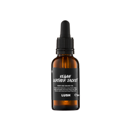 A small, amber glass bottle of "Vegan Leather Jacket" hair and beard oil by Lush. The bottle features a black label with white text and a black pipette dropper lid, containing 30ml of product.