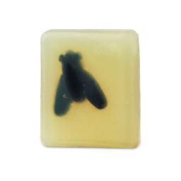 A rectangular bar of translucent, pale yellow soap with a dark fly silhouette embedded in the center.