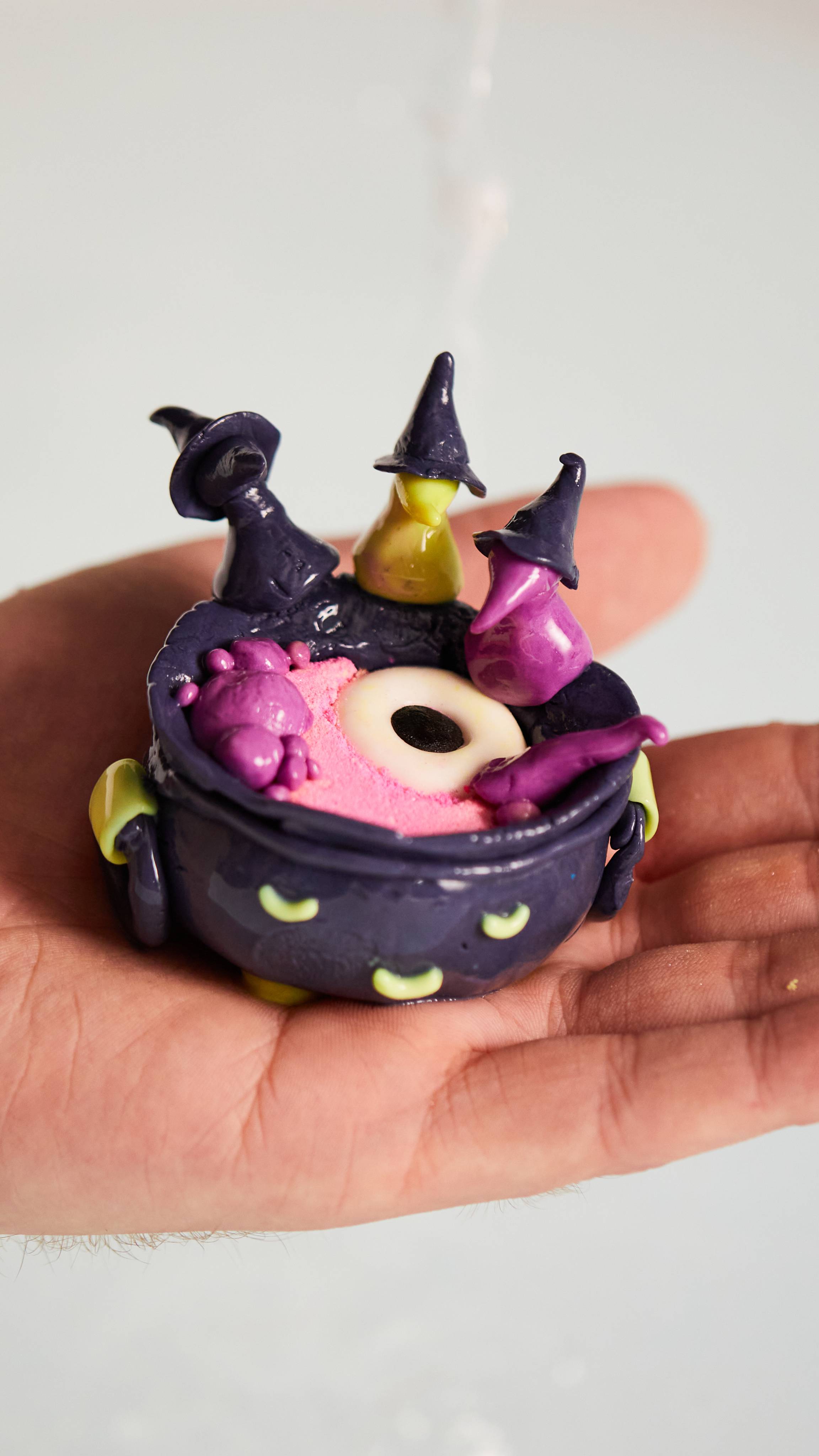 Image shows the products moulded into a big, bubbling cauldron surrounded by three colourful characters in witch hats.